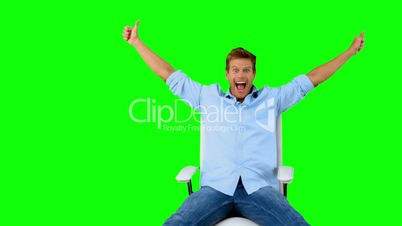 Man on swivel chair giving thumbs up on green screen