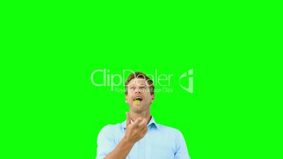 Man catching an orange segment with mouth on green screen