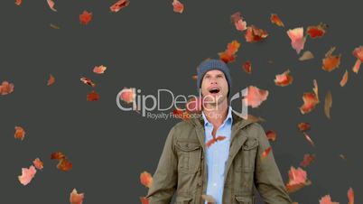 Amazed man looking at falling leaves on grey screen