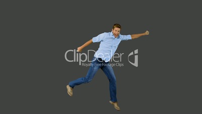 Man jumping and gesturing on grey screen