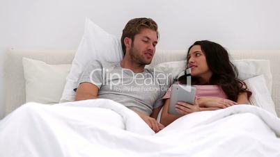 Couple using their tablet together and chatting