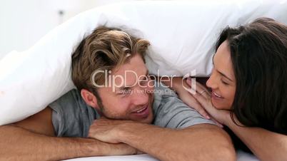Attractive couple cozy under the covers