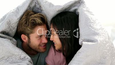 Couple chatting under the covers