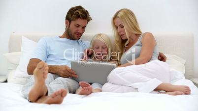 Parents and daughter using laptop together