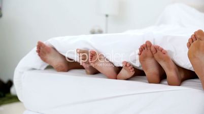 Family kicking their feet under the covers