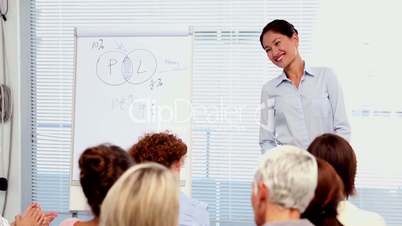 Businesswomen applauding colleague after presentation