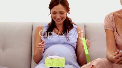 Woman opening a present at her baby shower