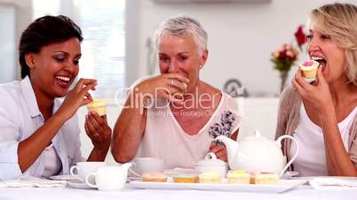 Retired women having cupcakes and tea together
