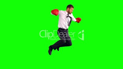 Businessman jumping with boxing gloves and punching
