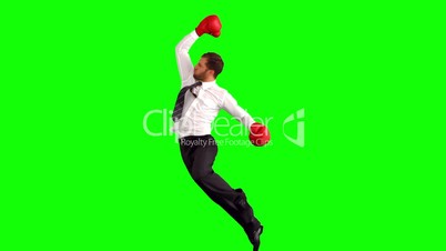 Businessman leaping with boxing gloves and punching