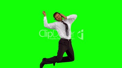 Businessman listening to music while jumping up