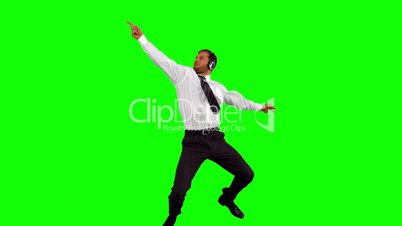 Businessman listening to music while jumping up disco dancing