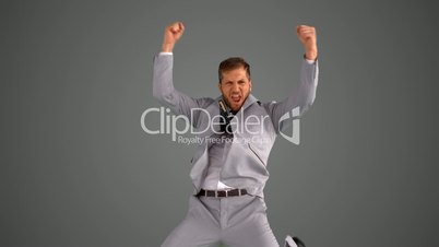Succesful businessman jumping on grey background