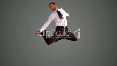Businessman jumping and stretching on grey background
