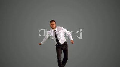 Businessman jumping and clicking heels on grey background
