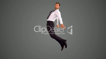 Businessman jumping and stretching out on grey background