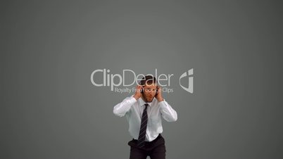 Businessman jumping and listening to music on grey background