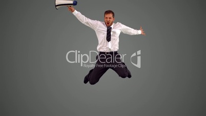 Businessman holding megaphone and jumping up on grey background