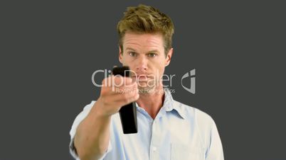 Man changing the channel on grey background
