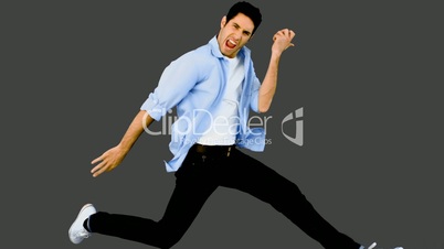 Man playing air guitar on grey background