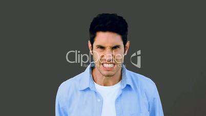 Man growling at camera angrily on grey background