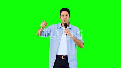 Man singing into microphone and dancing on green screen