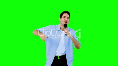 Man singing into microphone on green screen