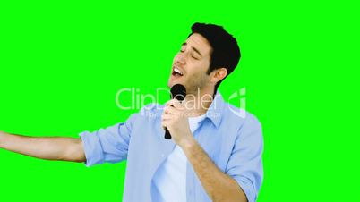 Man singing into microphone with emotion on green screen
