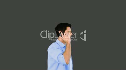 Angry man talking on phone and throwing it away on grey background