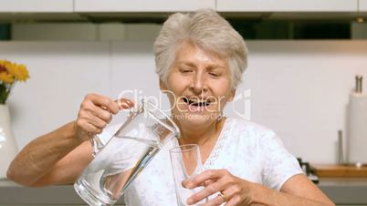 Happy woman pouring glass of water