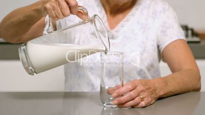 Woman pouring glass of milk