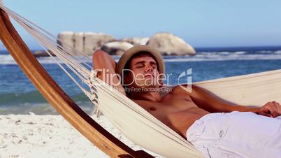 Man relaxing in a hammock on the beach