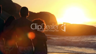 Silhouettes of friends relaxing while looking at the sunset