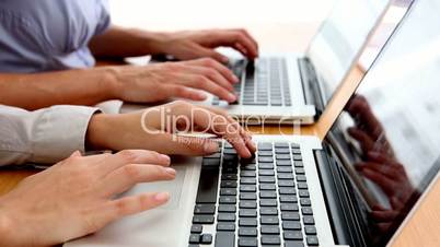 Business people typing on their laptops