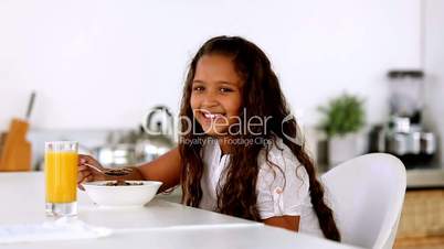 Little girl smiling at camera at breakfast