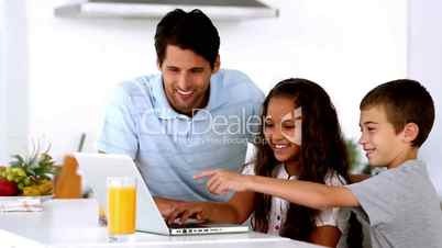 Father looking at laptop with his children