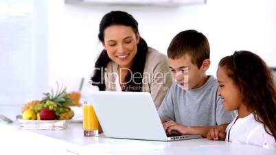 Mother looking at laptop with children