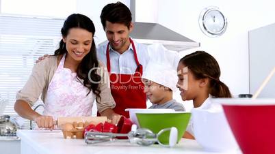 Family preparing cake together