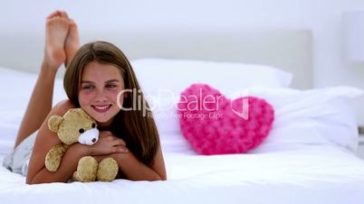 Cute girl smiling at camera holding teddy