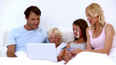 Cute family using laptop to shop online together