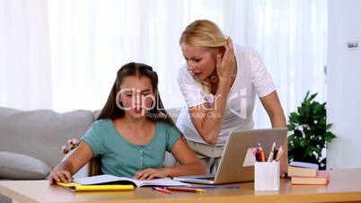 Mother helping her daughter with homework