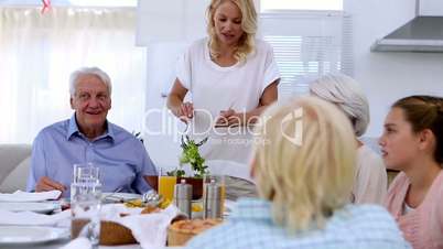 Woman serving salad at dinner table