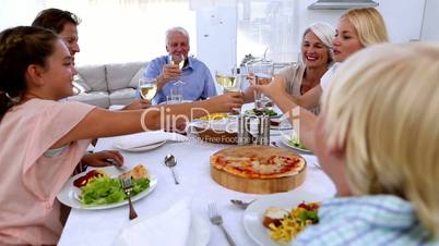 Family toasting at dinner table