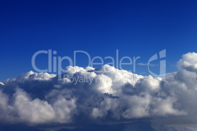 Blue sky and mountains covered with clouds