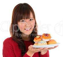Asian woman holding a plate of cakes