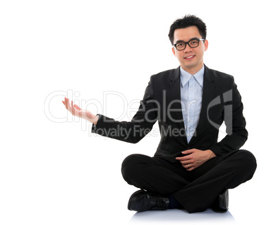 Asian business man showing blank space sit on floor