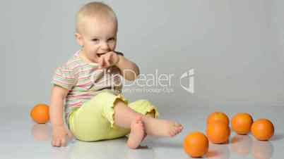 baby playing with oranges