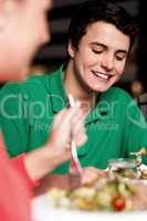 Handsome young guy enjoying meal in restaurant