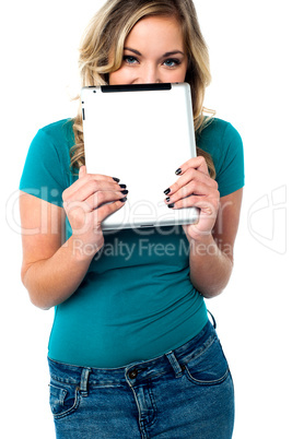 Shy pretty model hiding face with tablet pc