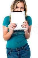 Shy pretty model hiding face with tablet pc